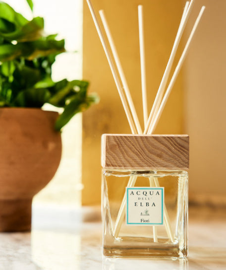 Reed diffuser with 'Acqua dell' Elba' branding on a blurred background